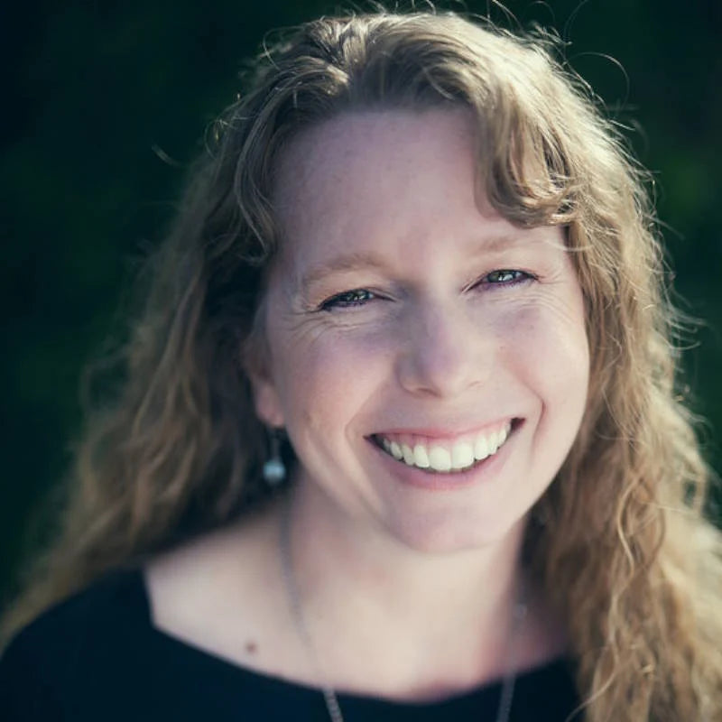 Woman with long curly hair smiling outdoors